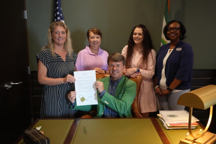 mayor in his office with members from the salvation army, holding up their proclamation paper